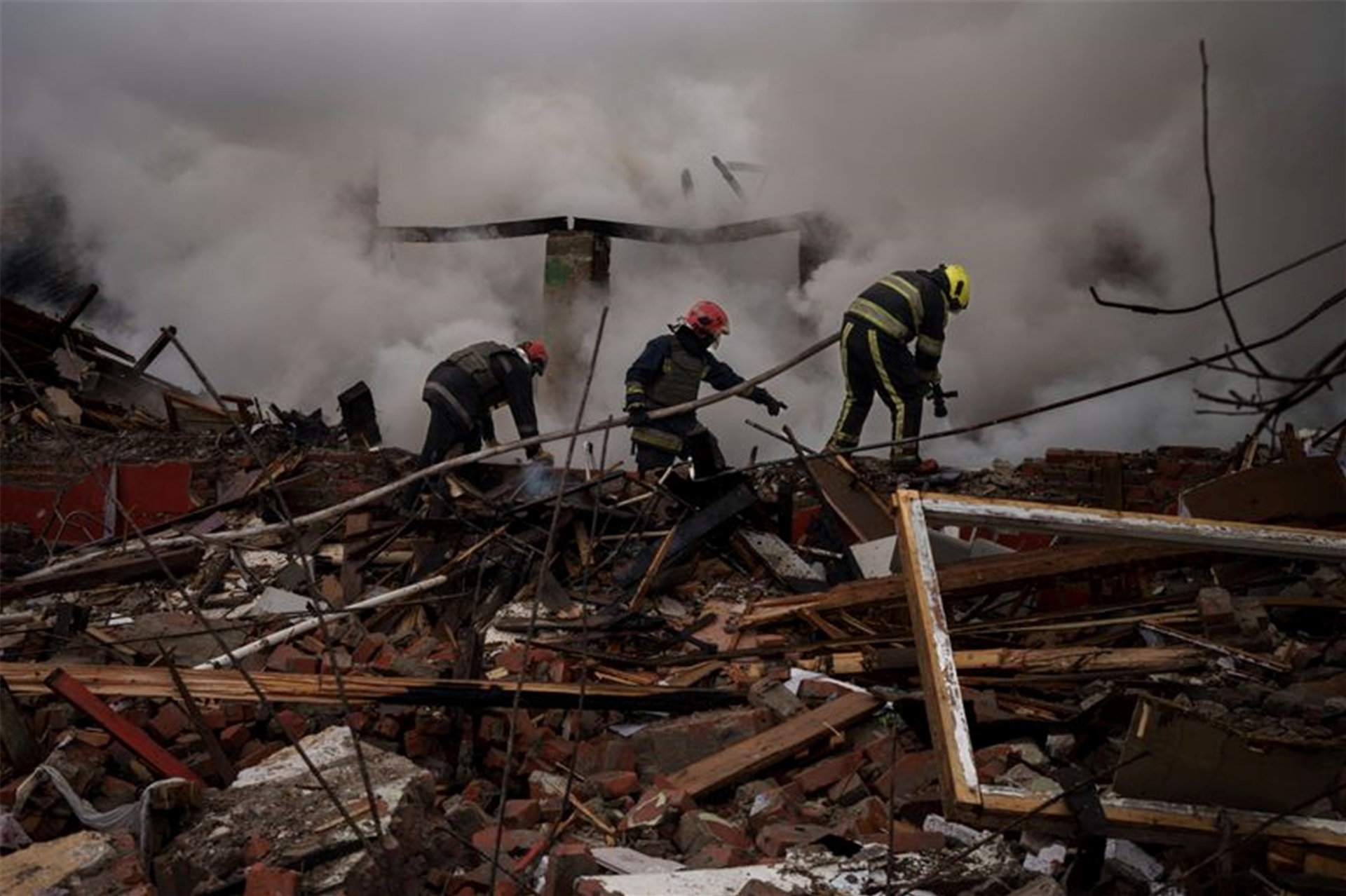 Feuerwehrleute arbeiten daran, ein Feuer nach einem russischen Angriff in Charkiw zu löschen.