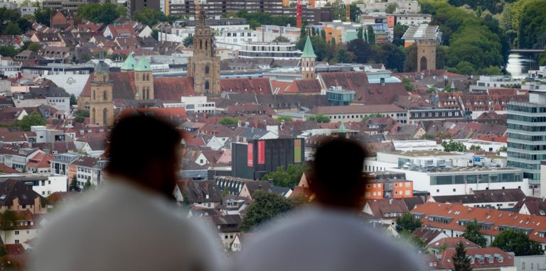 Zwei junge Männer genießen auf dem Wartberg den Blick auf die Stadt.