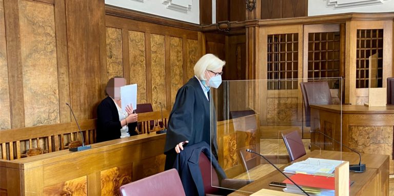 Die Angeklagte sitzt in einem Gerichtssaal in Duisburg.