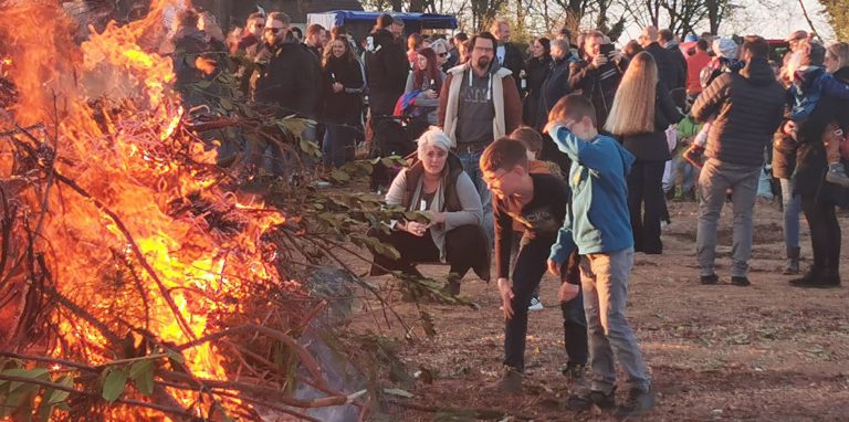 Neugierige Blicke und der nötige Sicherheitsabstand: Zahlreiche Familien besuchten das Osterfeuer am Wasserturm in Hengsen, das relativ schnell abbrannte.