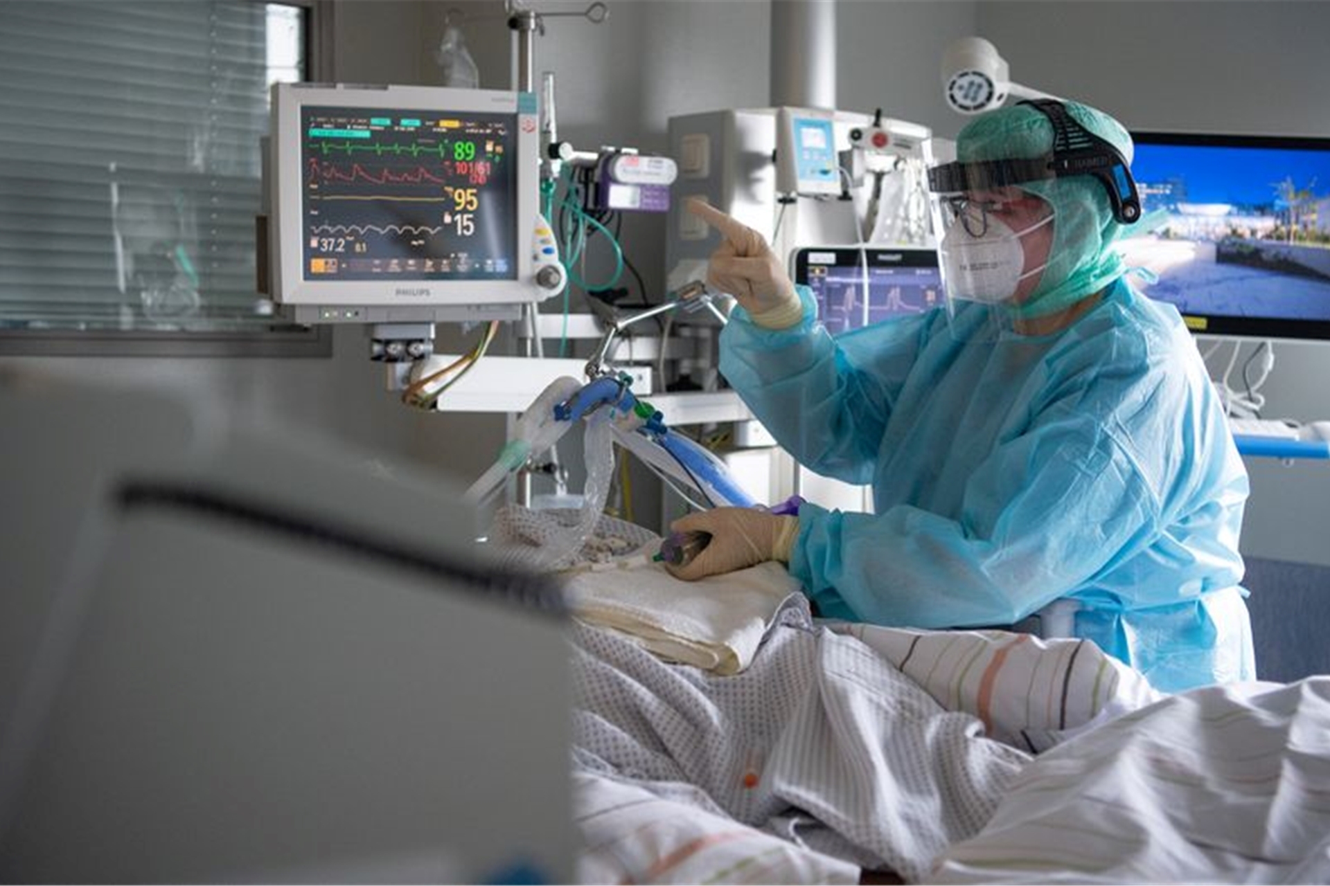 Eine Intensiv-Pflegerin versorgt einen schwer an Corona erkrankten Patienten auf der Intensivstation des Klinikums in Fulda.