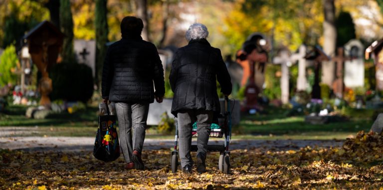 Zwei Frauen spazieren über einen Friedhof. Je nach Monat gibt es große Unterschiede bei den Sterbezahlen in Dortmund.