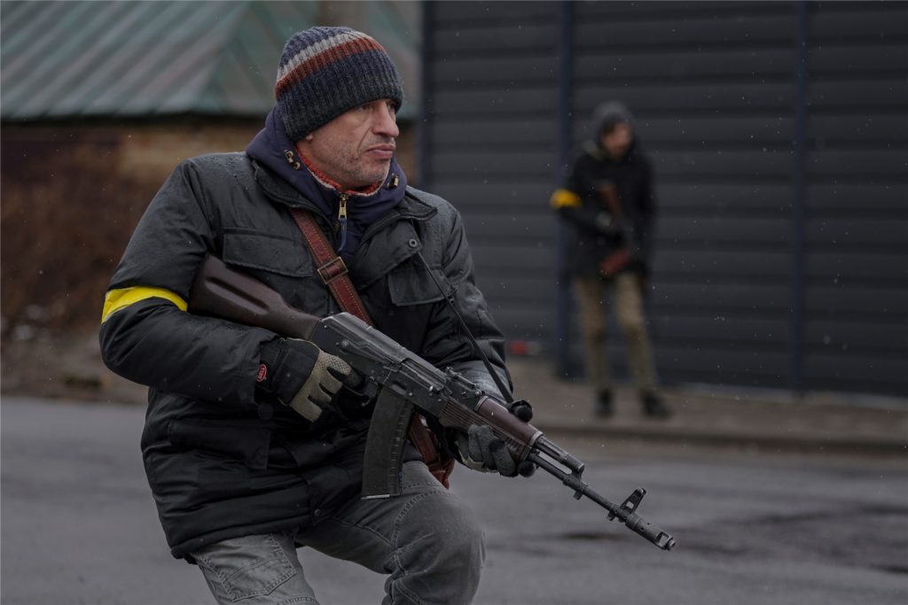 Ukraine, Gorenka: Mitglieder des Zivilschutzes gehen in Stellung, als sich ein Fahrzeug dem Kontrollpunkt in Gorenka außerhal