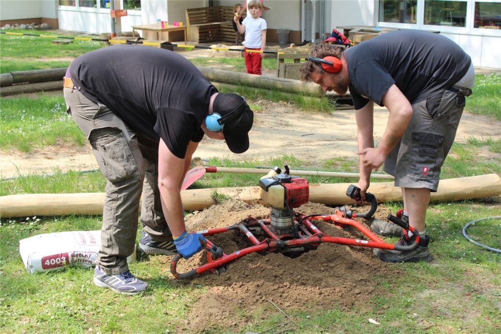 Mit einem Motorbohrer wurden die Löcher für die Pfosten und deren Fundamente erstellt. Teilweise erschwerten Steine trotz des hilfreichen Gerätes die Arbeit. Mit einem Motorbohrer wurden die Löcher für die Pfosten und deren Fundamente erstellt. Teilweise erschwerten Steine trotz des hilfreichen Gerätes die Arbeit.