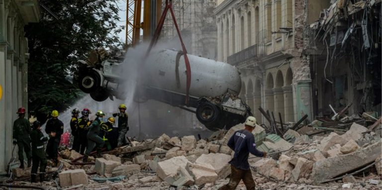 Feuerwehrleute besprühen nach einer Explosion in Havanna einen Tankwagen mit Wasser, um ihn zu kühlen.