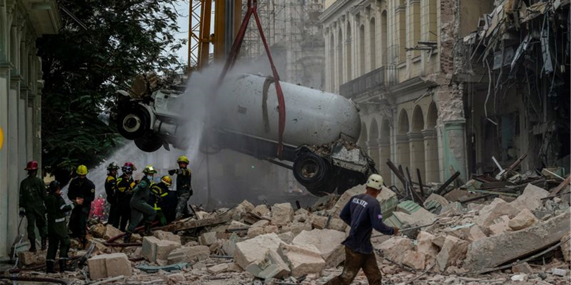 Feuerwehrleute besprühen nach einer Explosion in Havanna einen Tankwagen mit Wasser, um ihn zu kühlen.