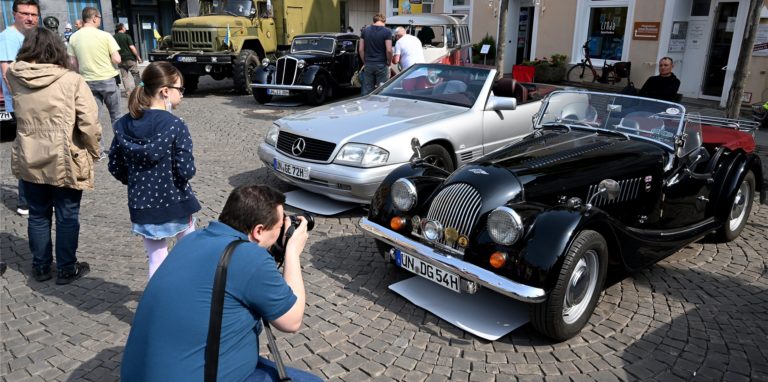 Ein Mann fotografiert ein Auto.
