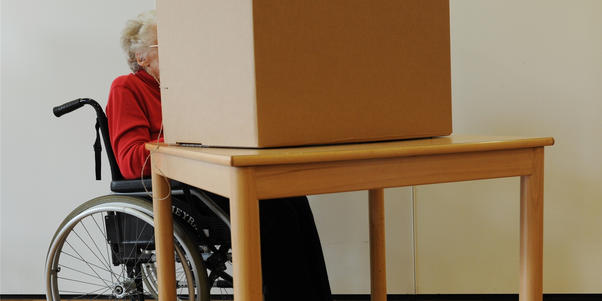 Eine Wählerin im Rollstuhl gibt in einem Wahllokal ihre Stimme ab. Nicht alle Wahllokale in Schwerte sind offiziell barrierefrei.