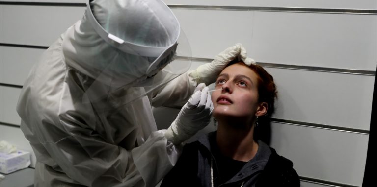 Person führt Corona-Test bei Frau durch