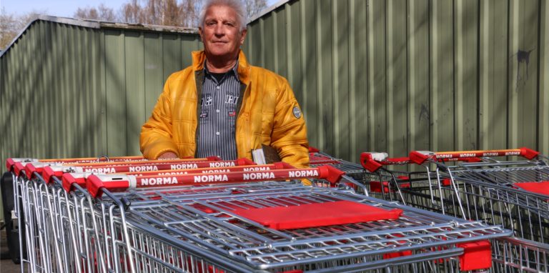 Peter Kunske und die abgestellten Einkaufswagen. Die Schlange ist beinahe so lang wie vor dem Supermarkt.