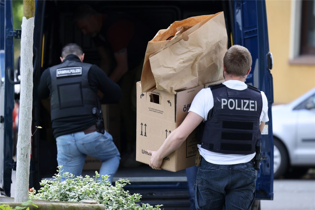 Polizisten tragen Gegenstände aus dem Wohnhaus des Tatverdächtigen. Polizisten tragen Gegenstände aus dem Wohnhaus des Tatverdächtigen.