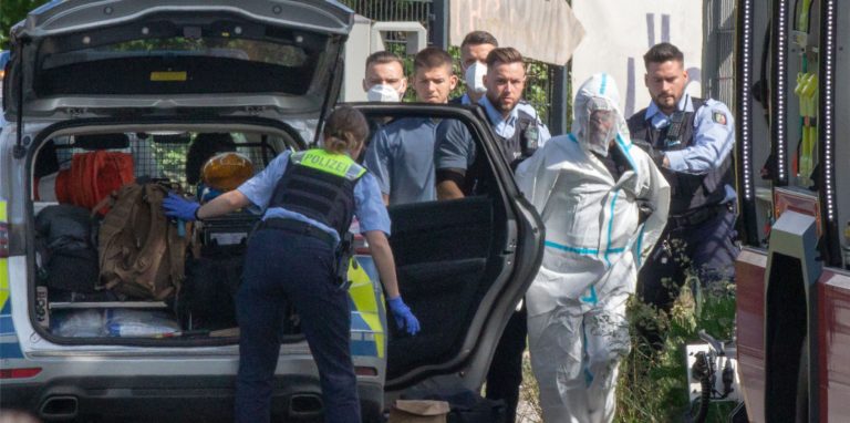 Polizisten führen den mutmaßlichen Täter ab. Der Mann soll in einer Regionalbahn mit einem Messer auf Reisende eingestochen haben.