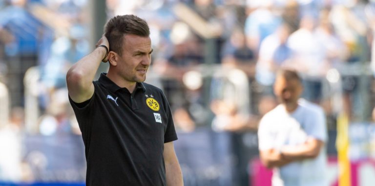 BVB-Trainer Enirco Maaßen fasst sich beim Spiel in München an den Hinterkopf.