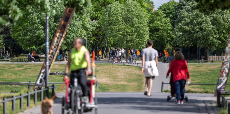 Zahlreiche Menschen spazieren bei warmen Temperaturen im Görlitzer Park.
