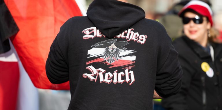 Reichsbürger sind längst nicht so einfach zu erkennen wie der Herr mit dem Hoodie auf diesem Symbolbild von einer Demonstration. In Unna verteilt die Szene derzeit Flyer.