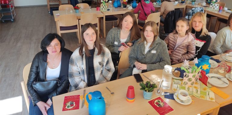Frauen sitzen an einem Tisch.