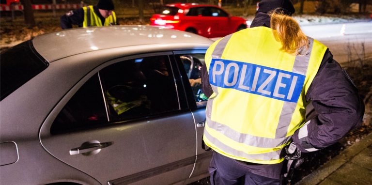 Eine Polizistin hat ein graues Auto gestoppt