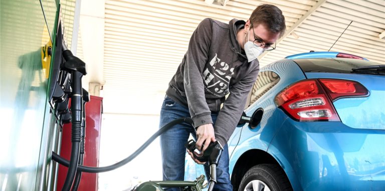 Ein Mann tankt an einer Tankstelle.