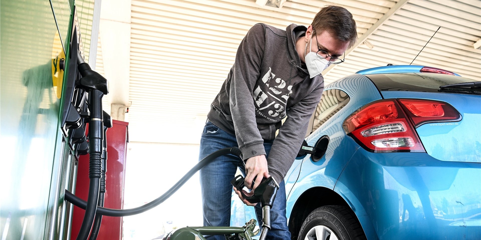 Ein Mann tankt an einer Tankstelle.