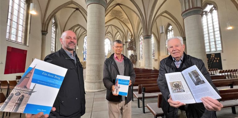 Dietrich Schneider vom Evangelischen Kirchenkreis (v. l.), der Historiker und Buchautor Klaus Basner sowie Hans-Peter Wigger vom Verein zur Erhaltung der Stadtkirche präsentieren ein spannendes neues Buch über das Gebäude: „Ein feste Burg“.