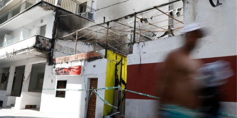 Menschen gehen nach dem Brand am Restaurant «Why Not Mallorca?» vorbei.