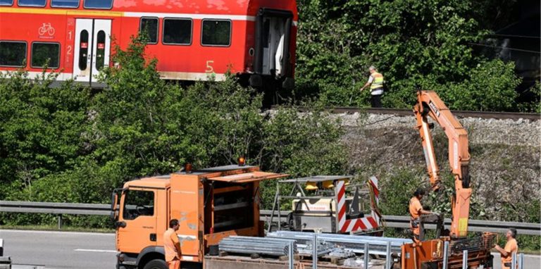 Arbeiter bereiten die Bundesstraße B2 neben der Zugunglücksstelle wieder für den Verkehr vor.