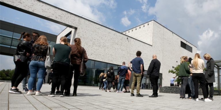 Studierende und Lehrende der Hochschule Hamm stehen trauernd vor dem Hörsaalgebäude der Hochschule.