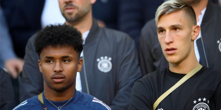Karim Adeyemi und Nico Schlotterbeck sitzen auf der Tribüne.