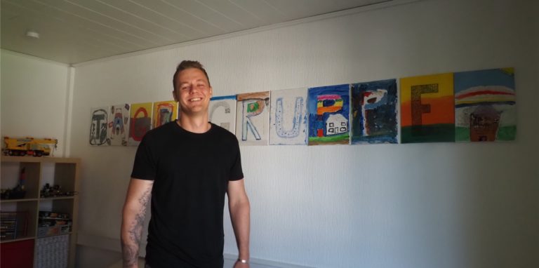 Marvin Czybulka ist seit zweieinhalb Jahren Leiter der „Tagesgruppe“ in Lünen. Zuvor wurde die Einrichtung von der Stadt betrieben. Das Schild im Hintergrund haben die Kinder gestaltet.