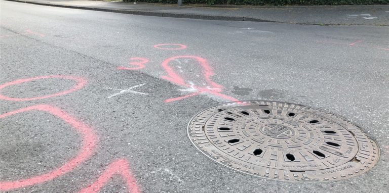Links erkennt man die Umrisse des Pedelecs auf dem Boden. Eine Straßenkehrmaschine hat am Montag (20.6.) einen 66-jährigen Dortmunder erfasst. Er wurde unter der Maschine eingeklemmt und schwer verletzt.