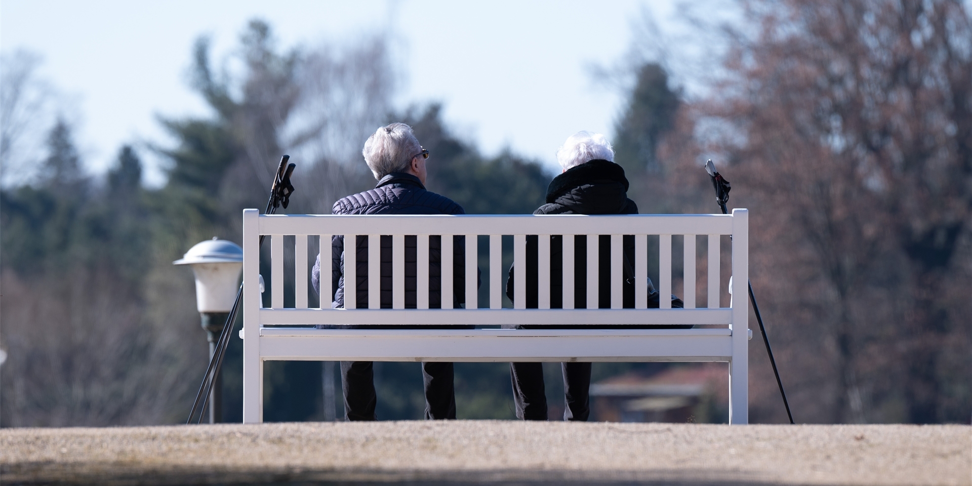 Rentner sitzen im Park auf einer Bank.