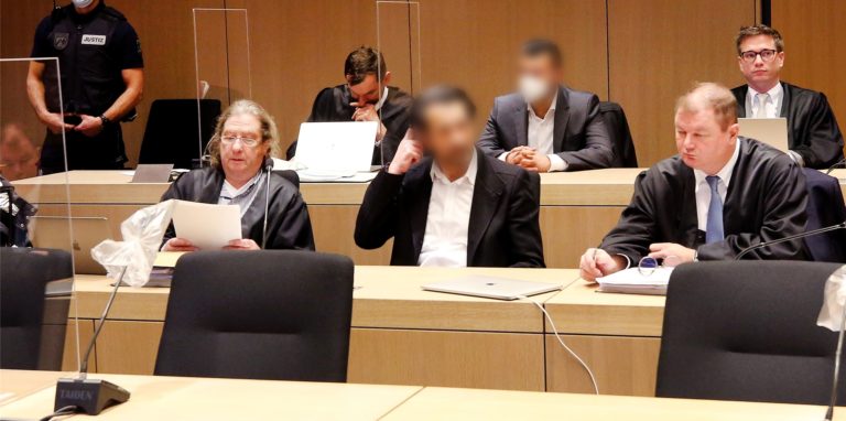 Die beiden Angeklagten (vordere Reihe Mitte und hintere Reihe Mitte) warten auf den Beginn des Prozesses.