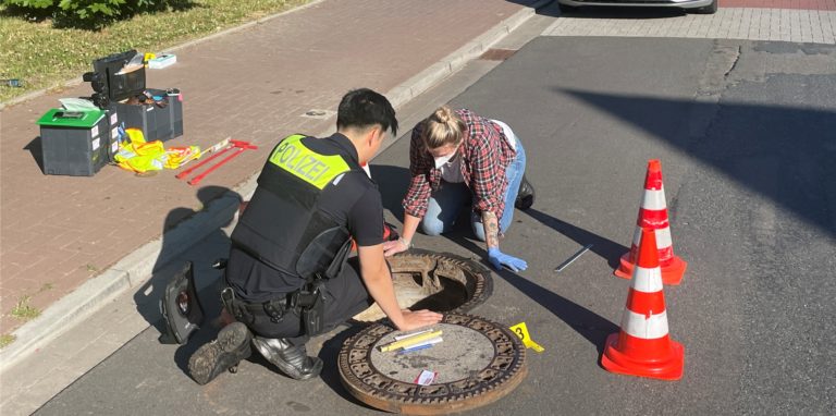 Polizisten untersuchen einen Gully, in dem ein seit acht Tagen vermisster Achtjähriger aus Oldenburg gefunden wurde.