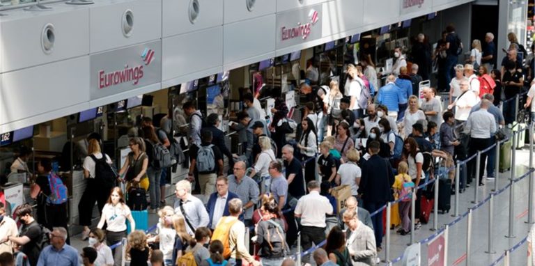 Passagiere stehen am Check-In Schalter von Eurowings am Flughafen Düsseldorf an.