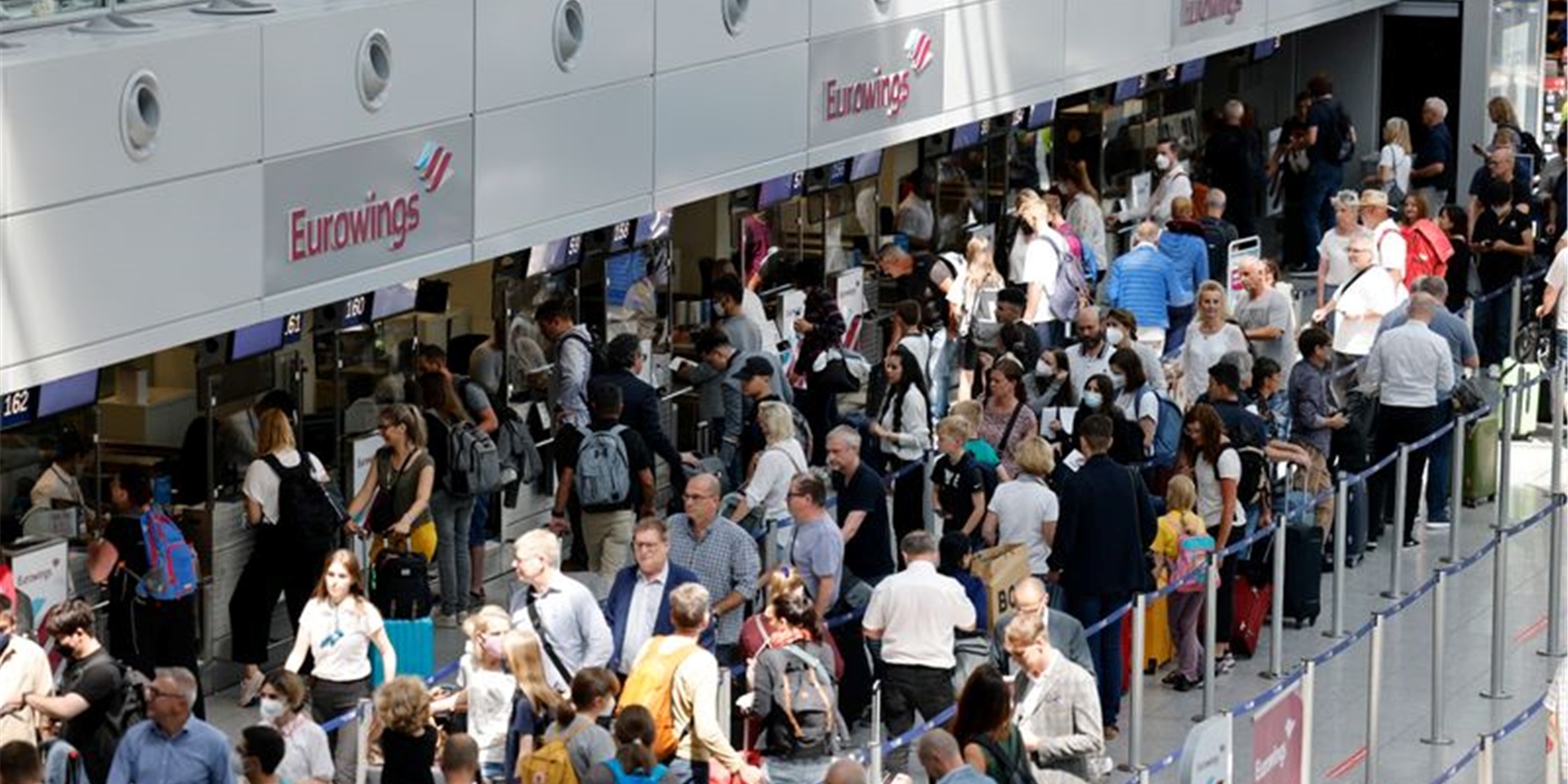 Passagiere stehen am Check-In Schalter von Eurowings am Flughafen Düsseldorf an.