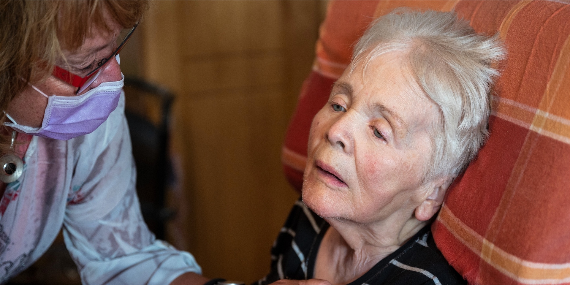 Birgit Rückert, Leiterin eines ambulanten Dienstes, drückt einer an Demenz und Parkinson erkrankten Patientin die Hand.