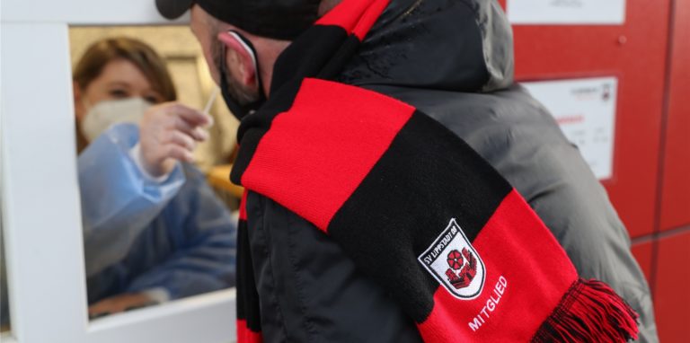 Ein Fußballfan lässt sich vor Spielbeginn auf das Corona-Virus testen.