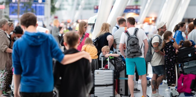 Reisende warten an einem Check-In-Schalter in der Abflughalle des Flughafens Düsseldorf.