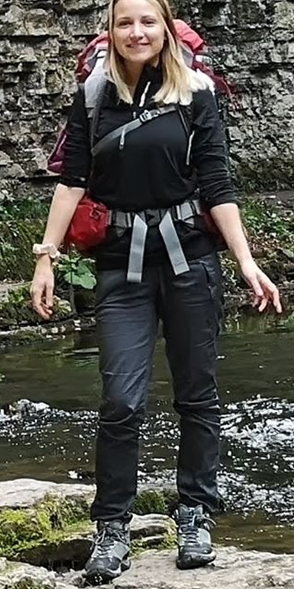 Das Bild zeigt eine junge Frau mit langen, dunkelblonden Haaren in Wanderkleidung und mit einem Rucksack. Das Bild zeigt eine junge Frau mit langen, dunkelblonden Haaren in Wanderkleidung und mit einem Rucksack.