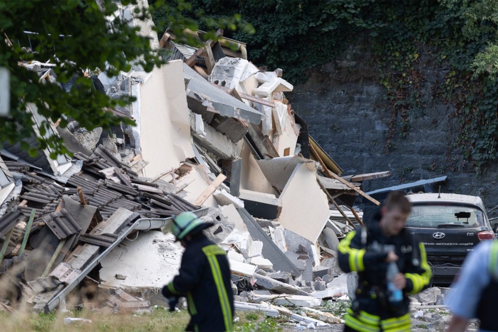Feuerwehrleute vor einem eingestürzten Haus. Feuerwehrleute vor einem eingestürzten Haus.