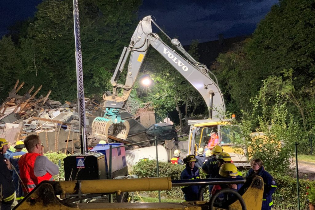 Ein Bagger vor einem eingestürzten Haus. Ein Bagger vor einem eingestürzten Haus.