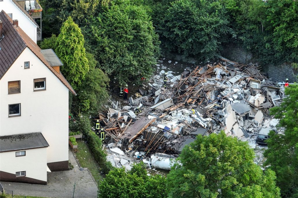 Feuerwehrleute untersuchen die Trümmer eines eingestürzten Hauses. Feuerwehrleute untersuchen die Trümmer eines eingestürzten Hauses.