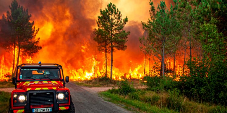 Dieses von der Feuerwehr der Region Gironde (SDIS33) zur Verfügung gestellte Foto zeigt einen Jeep der Feuerwehr, der vor einem Flächenbrand in der Nähe von Landiras im Südwesten Frankreichs auf der Straße parkt.