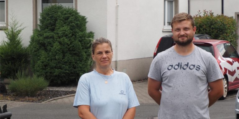 Astrid und Patrick Dähn stehen auf der Straße, auf der vor einem Jahr kniehoch das Wasser stand.