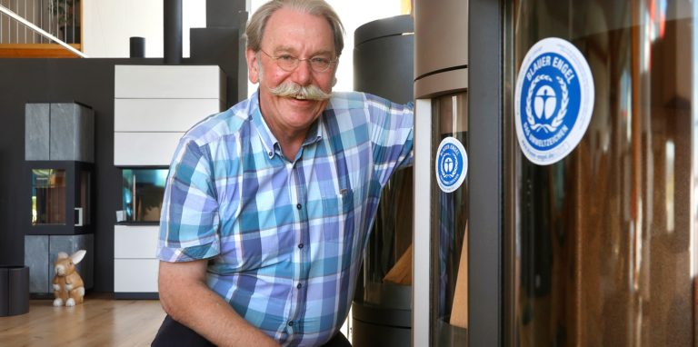 Georg Boldt vor einem Kaminofen mit dem „Blauen Engel“. „Diese Öfen zwingen zum richtigen Befeuern“, sagt der Kaminofen-Spezialist aus Kamen. Er hat einen solchen Boom, wie er gerade herrscht, zuvor noch nicht erlebt.
