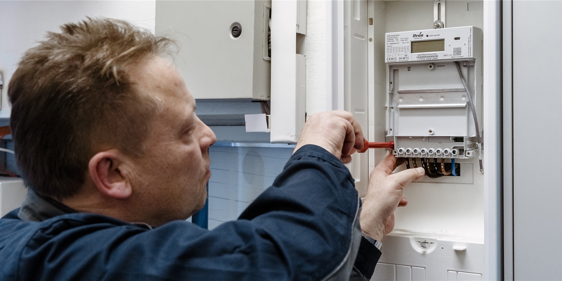 Ein Elektriker montiert einen digitalen Stromzähler.