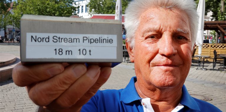 Peter Kunske mit einen massiven Stück der Nordsee-Pipeline Nordstream 2. Das kleine Musterstück aus Pipeline-Stahl ist schwer wie eine Hantel.