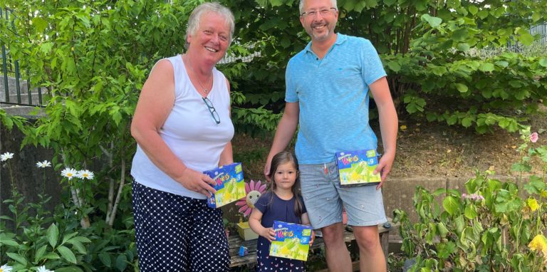Lars Krüger (rechts), verteilt Eis in Fröndenberg an Kindertagesstätten. Tochter Laura und Erika Neithart, die Leiterin der AWO-Kita auf dem Mühlenberg freuen sich.