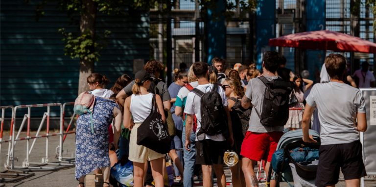 Zahlreiche Menschen stehen an den Kassen des Sommerbades Neukölln am Columbiadamm.