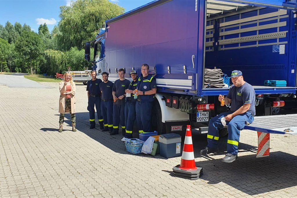 Männer und eine Frau stehen vor einem LKW. Männer und eine Frau stehen vor einem LKW.